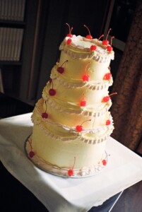 A four-tiered cream cake with cherries.