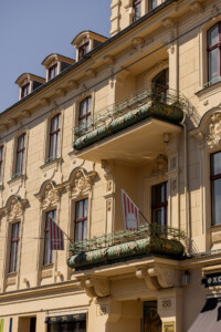 View of the historic hotel facade with grand balconies and decorative stucco details.