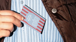 Close-up of a hand pulling a Le doux Souvenir room card out of a jacket pocket.
