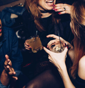 Friends enjoying cocktails together at a lively bar, capturing a vibrant and social evening atmosphere.