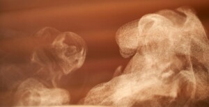 Fine steam particles swirling in warm light.